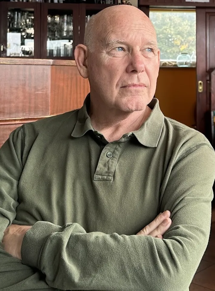 Eric L. Qualkenbush, arms folded, photographed indoors